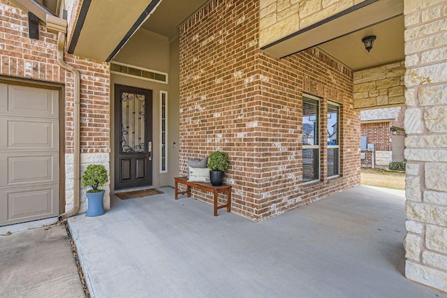 property entrance featuring brick siding and an attached garage