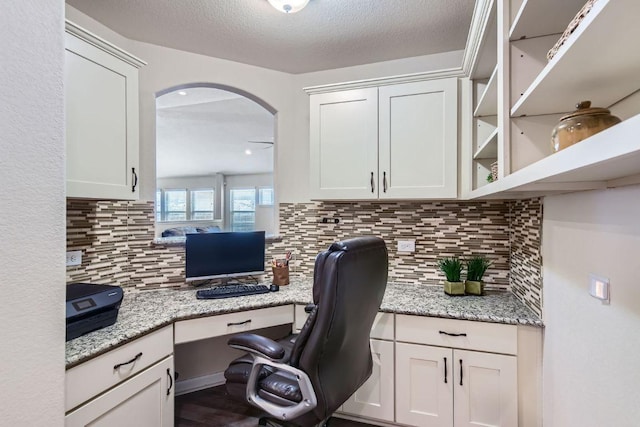 office area with built in desk and a textured ceiling