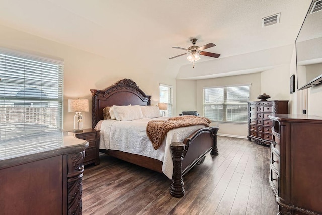 bedroom featuring a ceiling fan, dark wood-style floors, visible vents, and baseboards