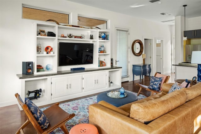 living area with visible vents, baseboards, and wood finished floors