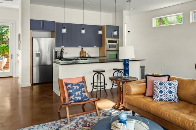 living room with a wealth of natural light, finished concrete floors, baseboards, and visible vents