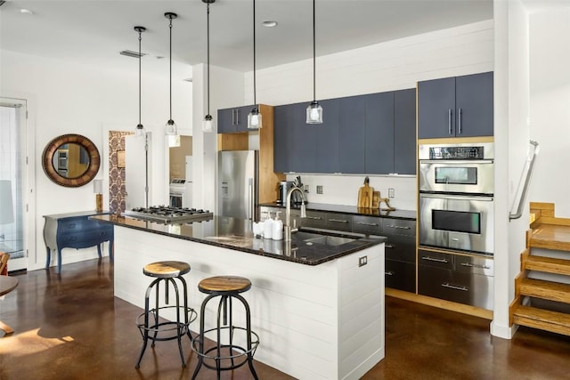 kitchen with a sink, stainless steel appliances, a kitchen breakfast bar, and concrete flooring