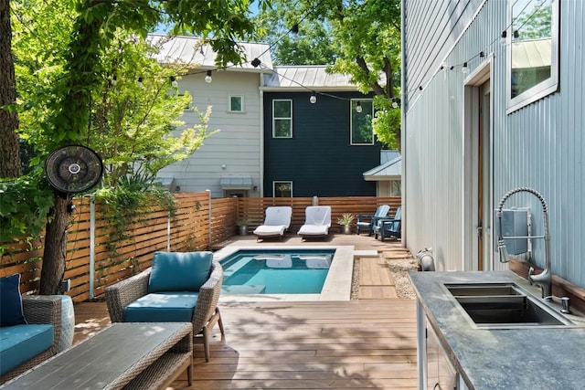 view of pool featuring a fenced in pool, a deck, and a sink