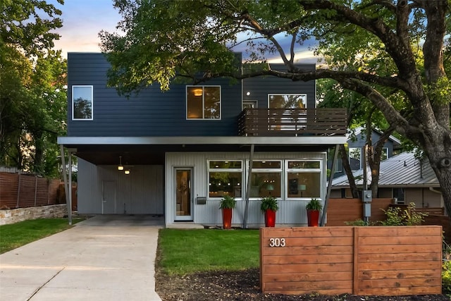 modern home with a carport, driveway, and fence