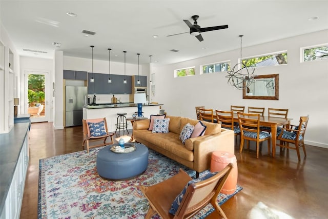 living room with a wealth of natural light, visible vents, recessed lighting, and finished concrete flooring