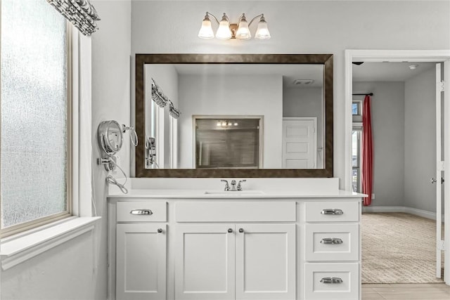 bathroom with visible vents, baseboards, a notable chandelier, and vanity