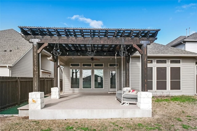 rear view of property featuring a pergola, fence, a shingled roof, ceiling fan, and a patio area