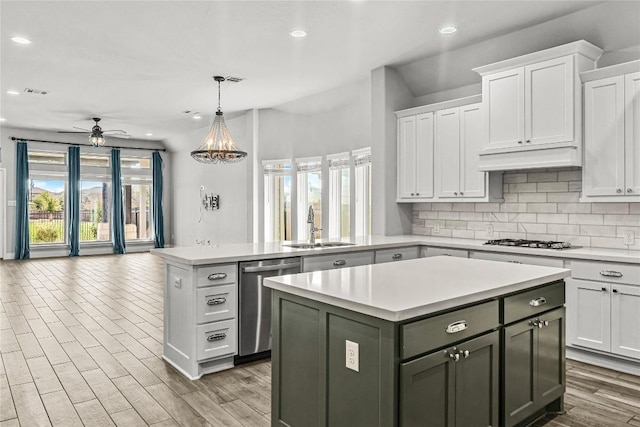 kitchen with a sink, stainless steel dishwasher, a center island, gas stovetop, and a peninsula