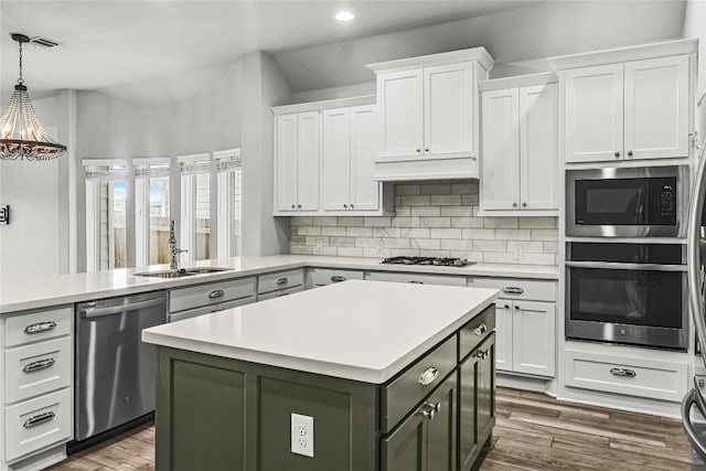 kitchen featuring white cabinets, stainless steel appliances, light countertops, and a sink