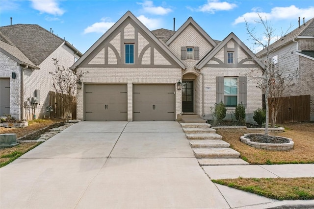 view of front of house with brick siding, concrete driveway, a garage, and fence