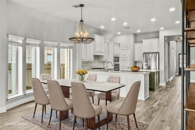 dining area featuring recessed lighting, baseboards, an inviting chandelier, and light wood-style flooring