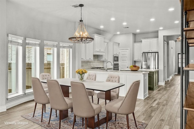 dining room featuring light wood finished floors, baseboards, recessed lighting, and a chandelier
