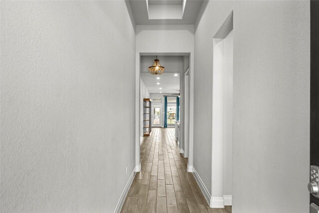 corridor featuring baseboards and wood finished floors