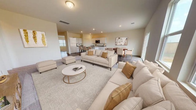 living area with recessed lighting, visible vents, and a wealth of natural light