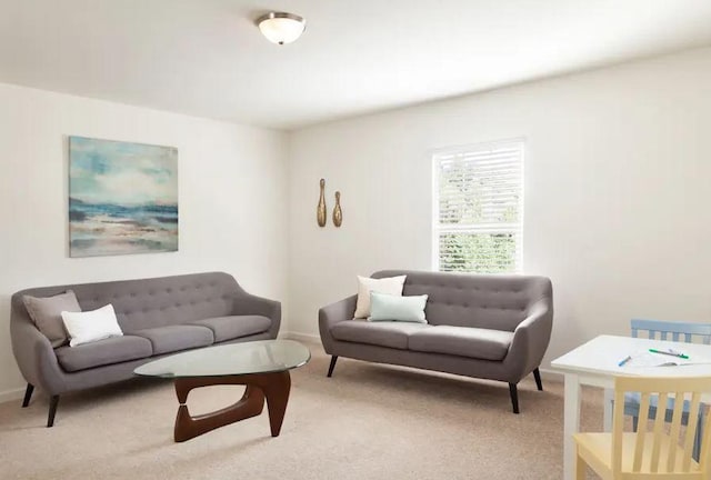 living room featuring baseboards and light colored carpet