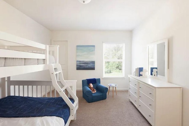 bedroom with light colored carpet and baseboards