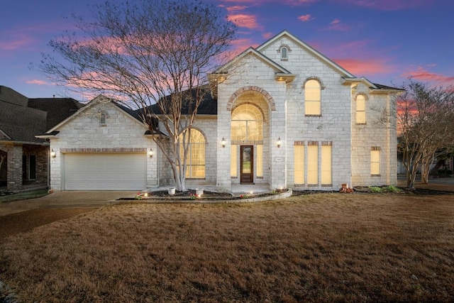 french country home featuring a front lawn, a garage, and driveway