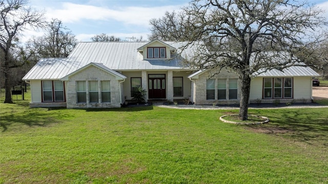 view of front facade featuring stone siding, metal roof, and a front lawn