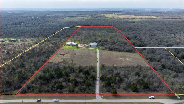 bird's eye view featuring a view of trees and a rural view