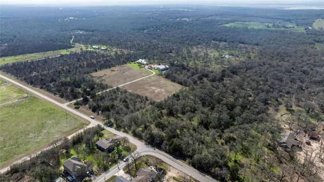 drone / aerial view featuring a rural view and a view of trees