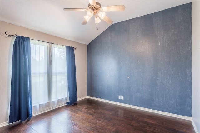 empty room featuring ceiling fan, vaulted ceiling, wood finished floors, and baseboards