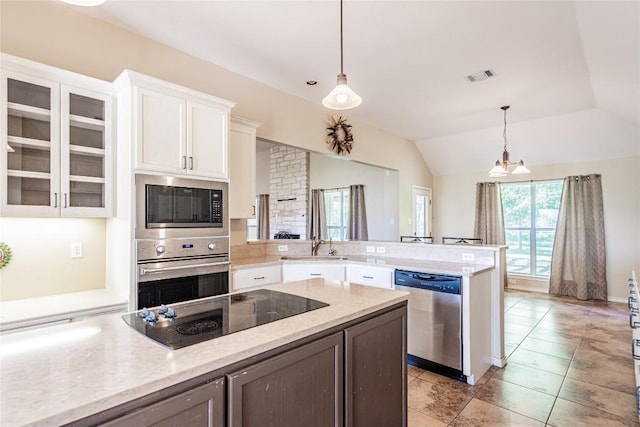 kitchen featuring a peninsula, white cabinets, visible vents, appliances with stainless steel finishes, and hanging light fixtures