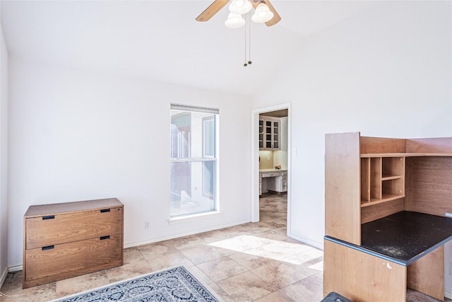 interior space featuring baseboards, a ceiling fan, and lofted ceiling
