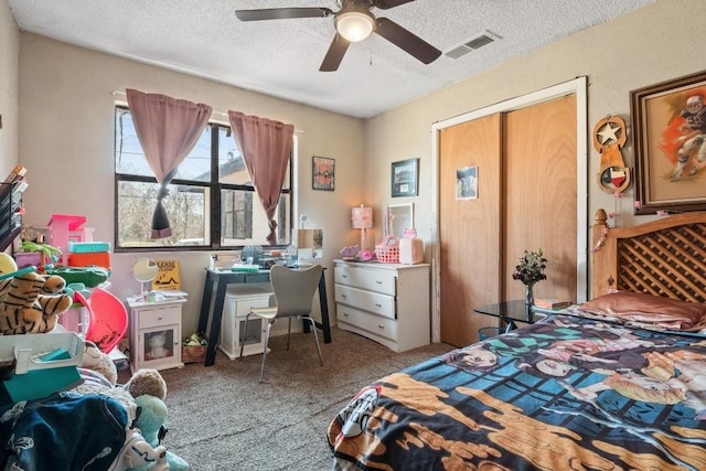 carpeted bedroom with visible vents, a textured ceiling, and ceiling fan