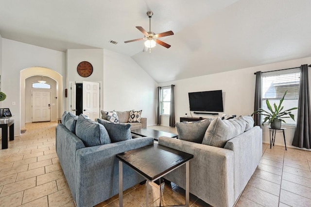 living room with a ceiling fan, lofted ceiling, visible vents, and arched walkways