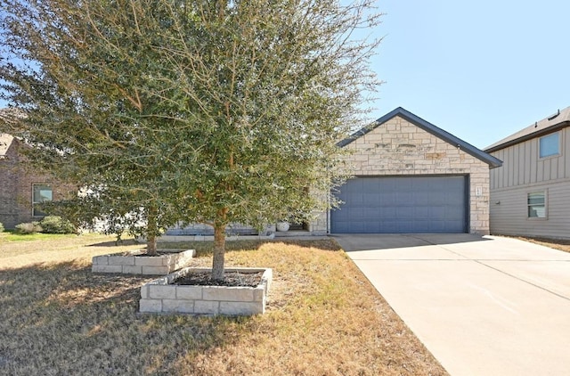 view of front of house featuring a garage, stone siding, and concrete driveway