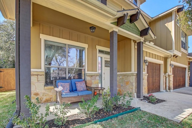 property entrance featuring a porch, stone siding, board and batten siding, and driveway