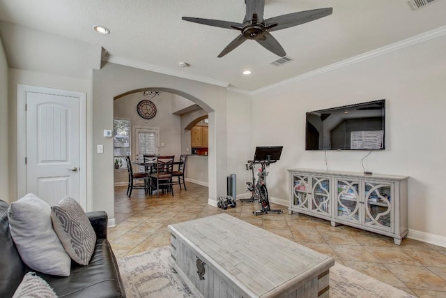 living area with visible vents, baseboards, recessed lighting, arched walkways, and crown molding