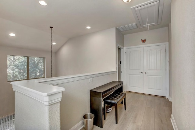 hall with attic access, recessed lighting, vaulted ceiling, an upstairs landing, and light wood-type flooring