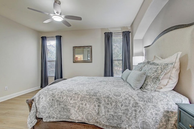 bedroom featuring a ceiling fan, baseboards, and wood finished floors