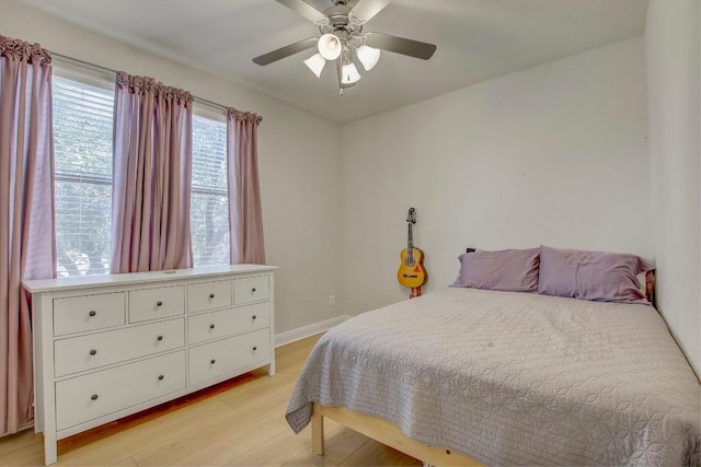 bedroom with light wood-type flooring, baseboards, and a ceiling fan