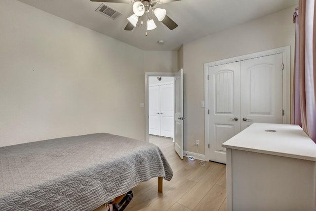 bedroom with visible vents, a closet, light wood-style floors, baseboards, and ceiling fan