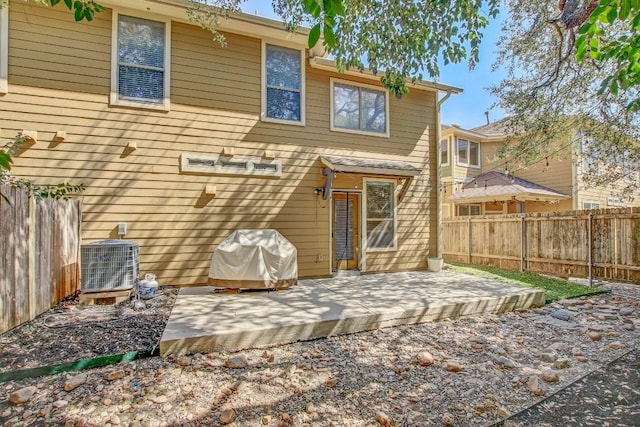 rear view of house featuring central AC unit, a patio, and fence