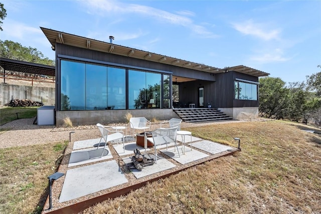 rear view of house with a patio area, a yard, and a sunroom