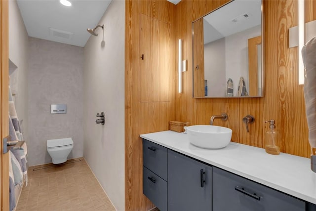 bathroom with visible vents, toilet, vanity, and a shower