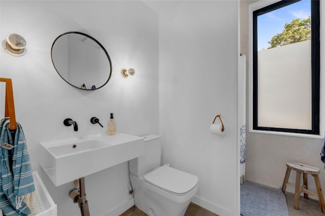 bathroom with toilet and baseboards