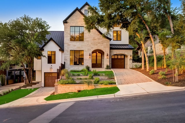 view of front of home featuring decorative driveway, a garage, metal roof, and a standing seam roof