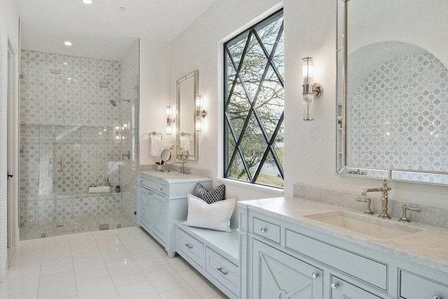 full bath with tile patterned flooring, a walk in shower, two vanities, and a sink