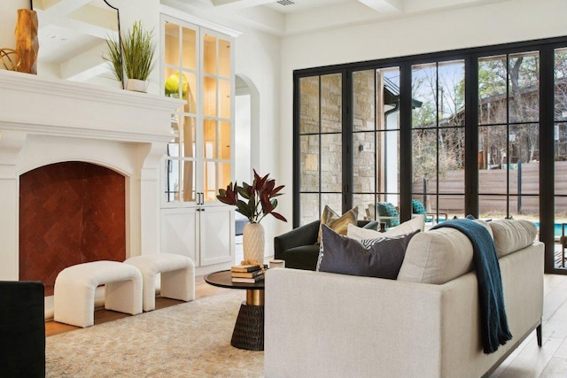 living area featuring beam ceiling and arched walkways