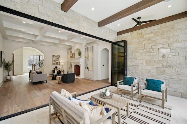 interior space featuring beamed ceiling, light wood-style flooring, recessed lighting, arched walkways, and ceiling fan