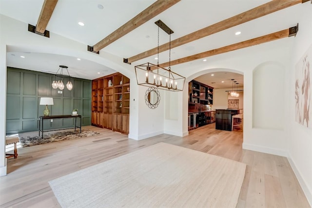 interior space featuring beam ceiling, built in shelves, light wood-style floors, and recessed lighting