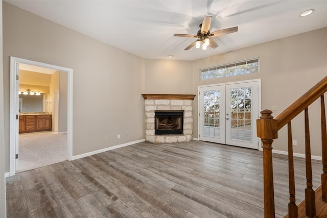 unfurnished living room featuring wood finished floors, stairway, french doors, and baseboards