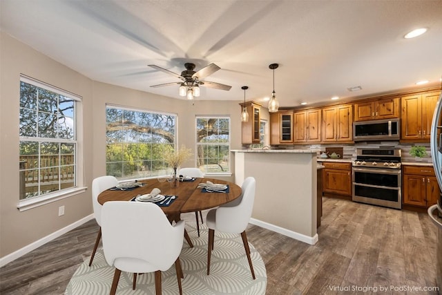 dining space featuring baseboards, plenty of natural light, and wood finished floors