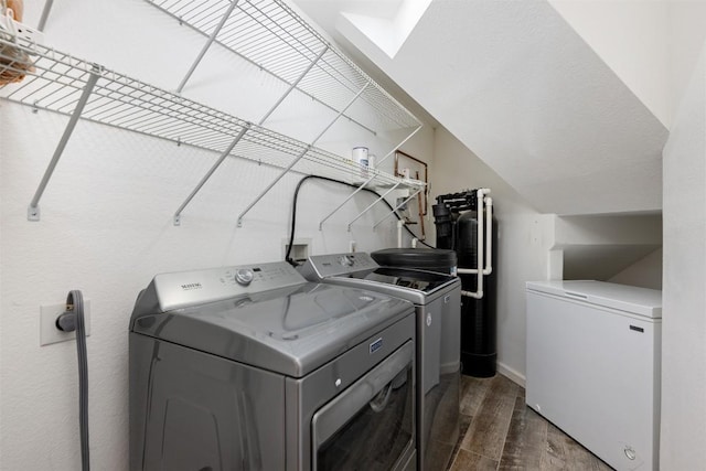 laundry area featuring baseboards, dark wood-type flooring, laundry area, and washing machine and clothes dryer