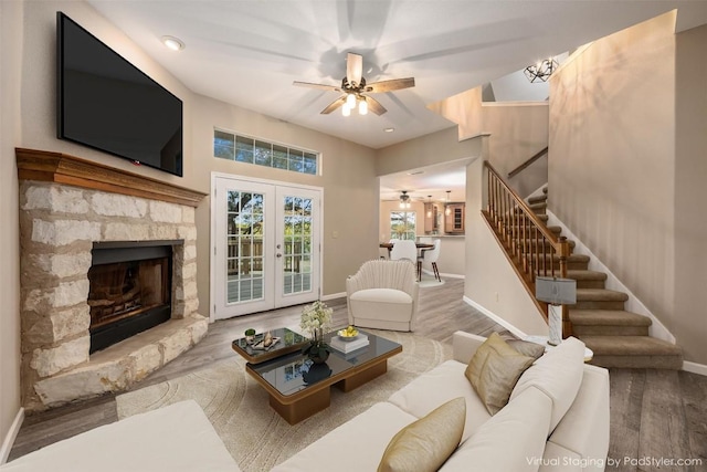 living area with ceiling fan, stairway, baseboards, and wood finished floors