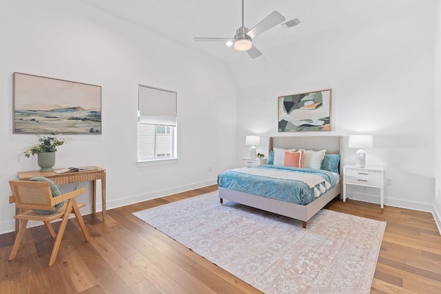 bedroom featuring visible vents, hardwood / wood-style flooring, baseboards, and vaulted ceiling